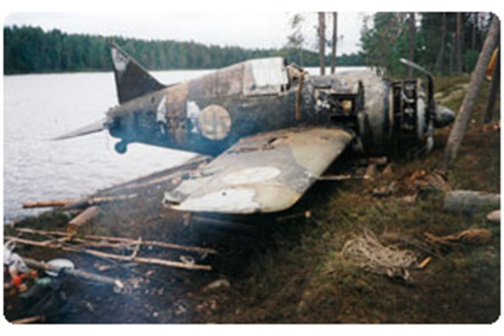 Maahan tippunut pommikone järven rannalla.
