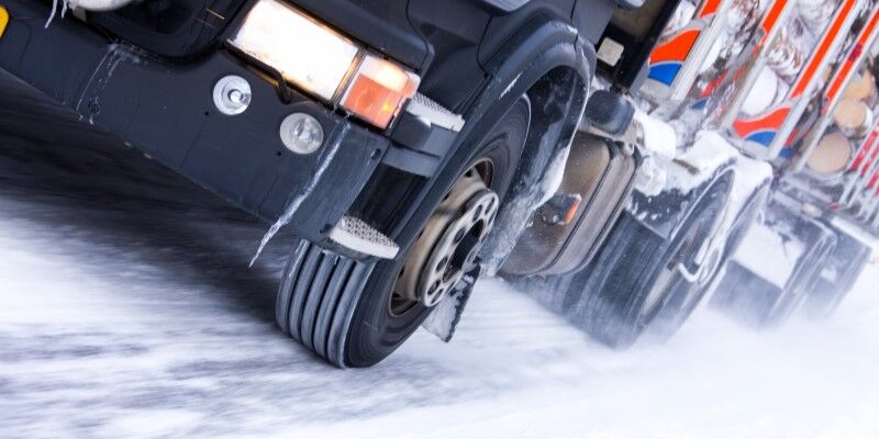 Shot of a moving truck's tires on a snowy surface