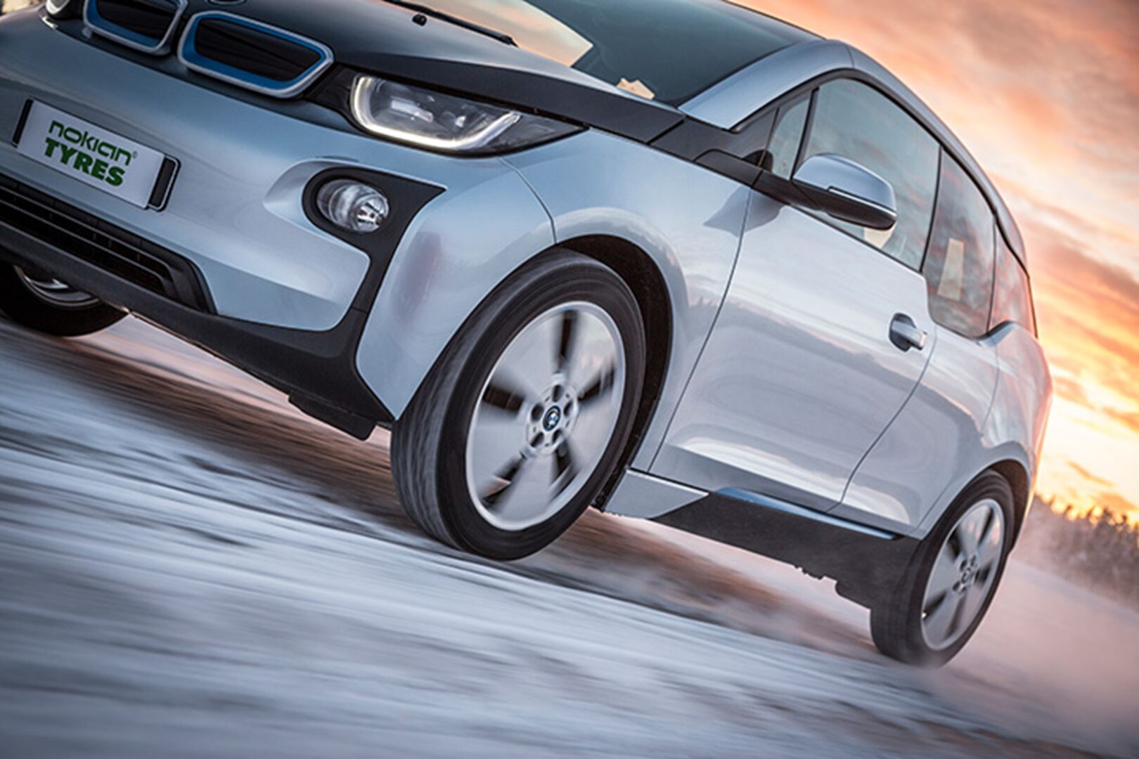 Dynaaminen tuotekuva, jossa auto viilettää talvisella tiellä 