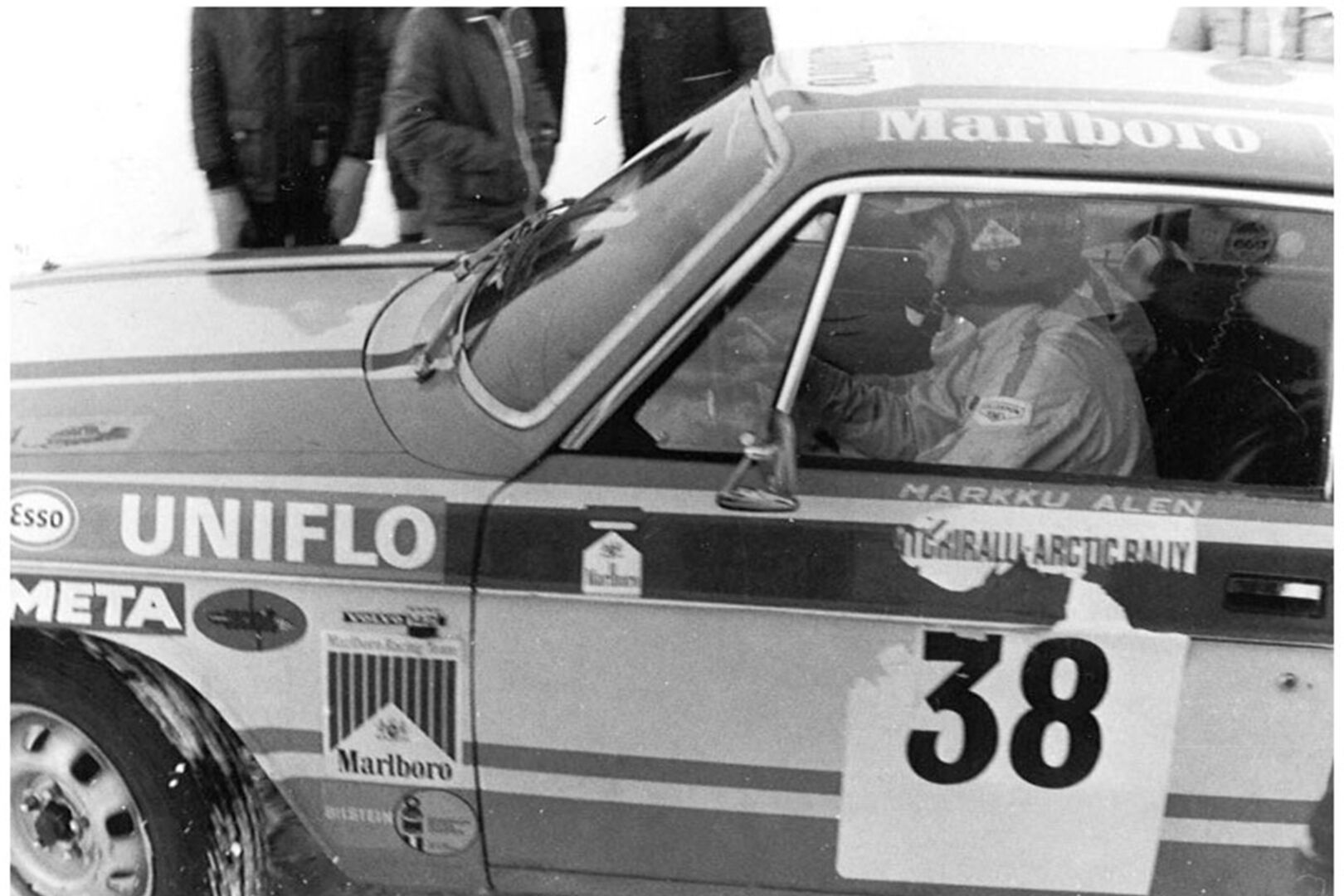 Ralliauto ja etuikkunan takana sen kuski