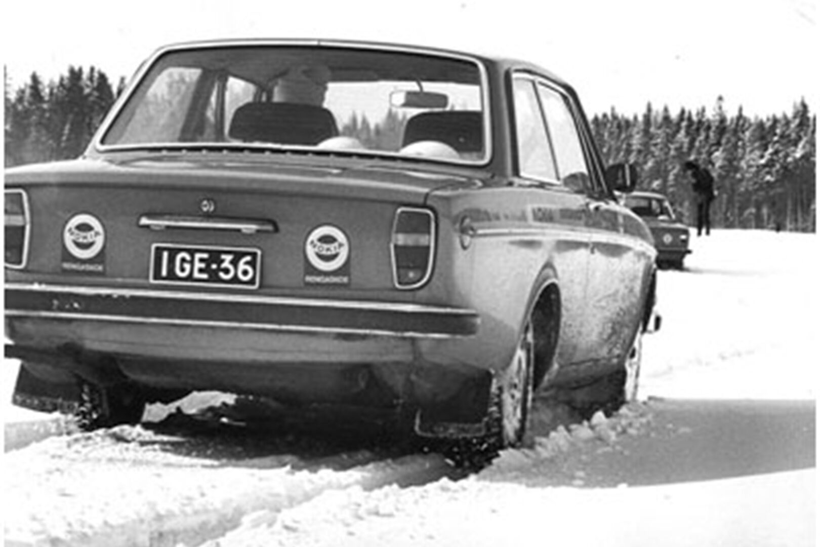 Auto ajamassa paksussa lumessa, jättäen jälkeensä urat