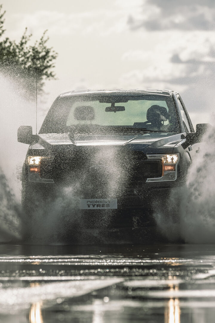Car passing a puddle, water splashes high