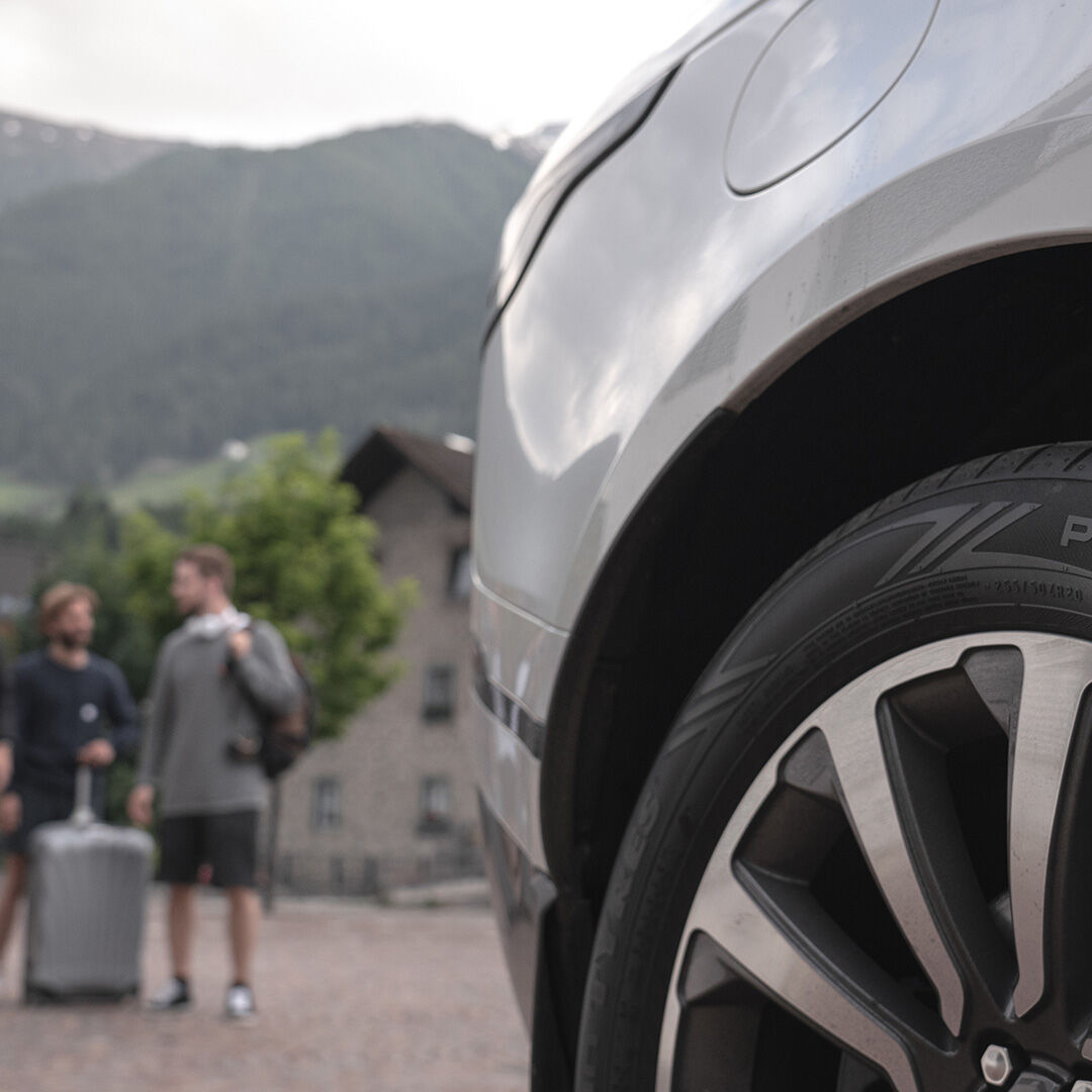 Travellers standing next to a car.
