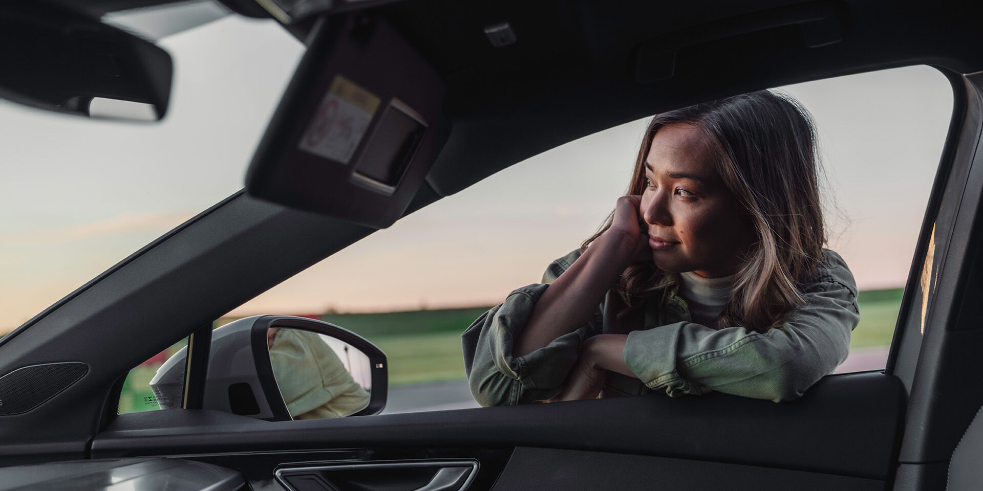 Woman leaning in car window glancing forward