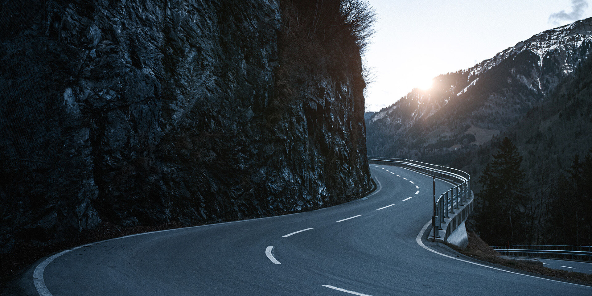Aerial image of snowy mountain road in sunset