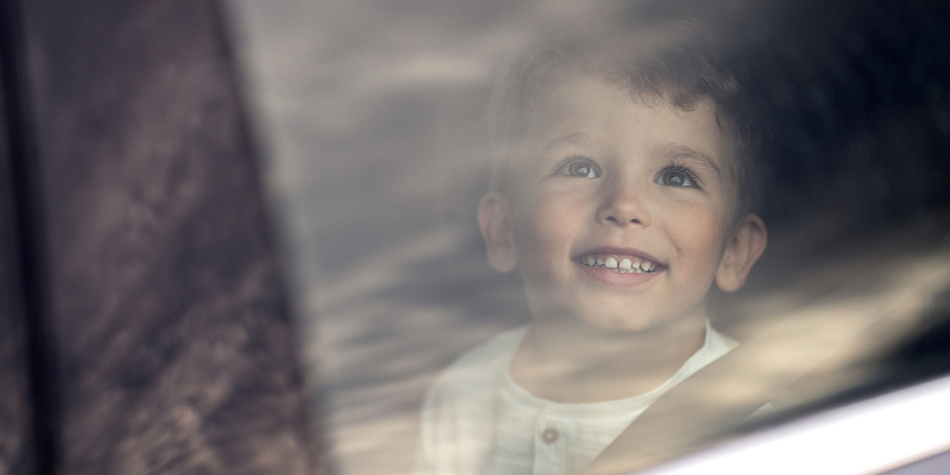 young boy smiling in car