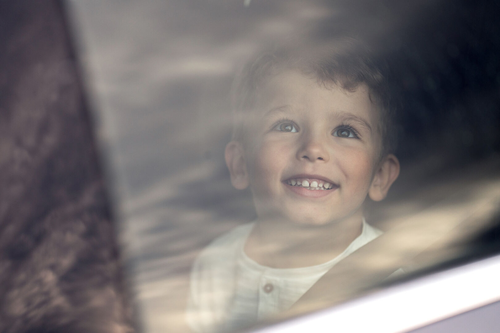 young boy smiling in car