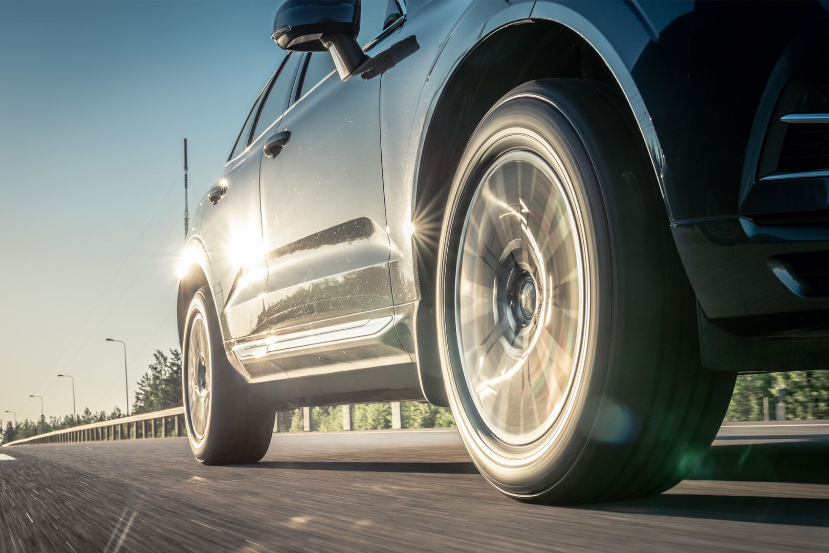 Auto ajaa kuivalla, aurinkoisella tiellä