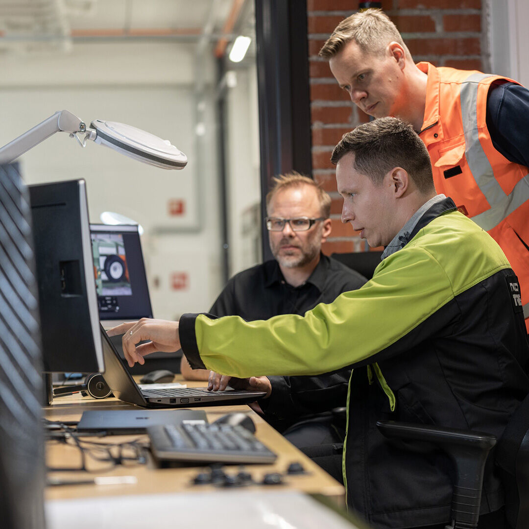 Three Nokian Tyres team members working together at a screen