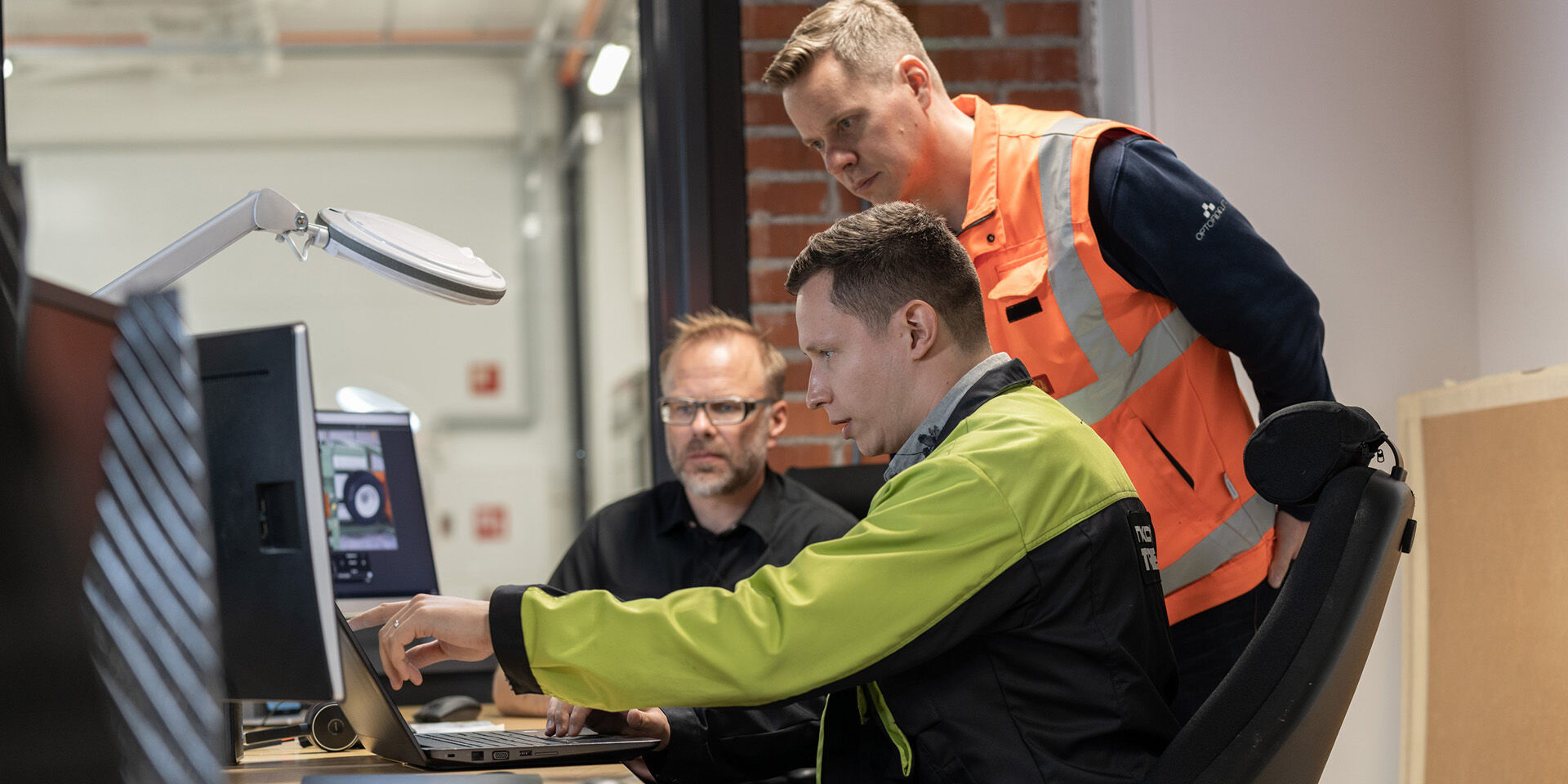 Three Nokian Tyres team members working together at a screen