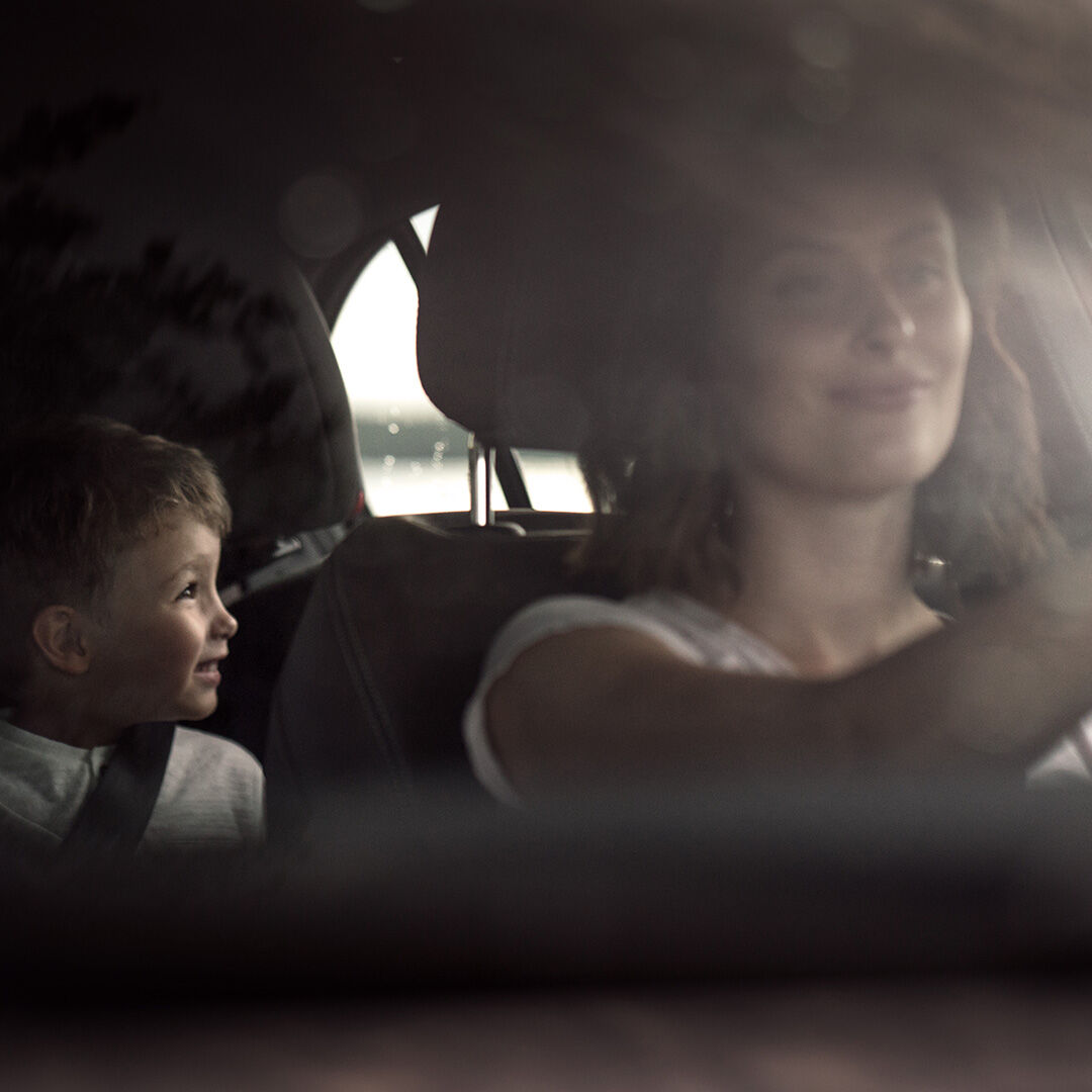 mother driving and child on the back seat