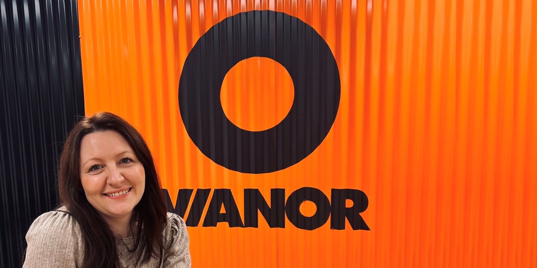 Person smiling in front of a Vianor logo.