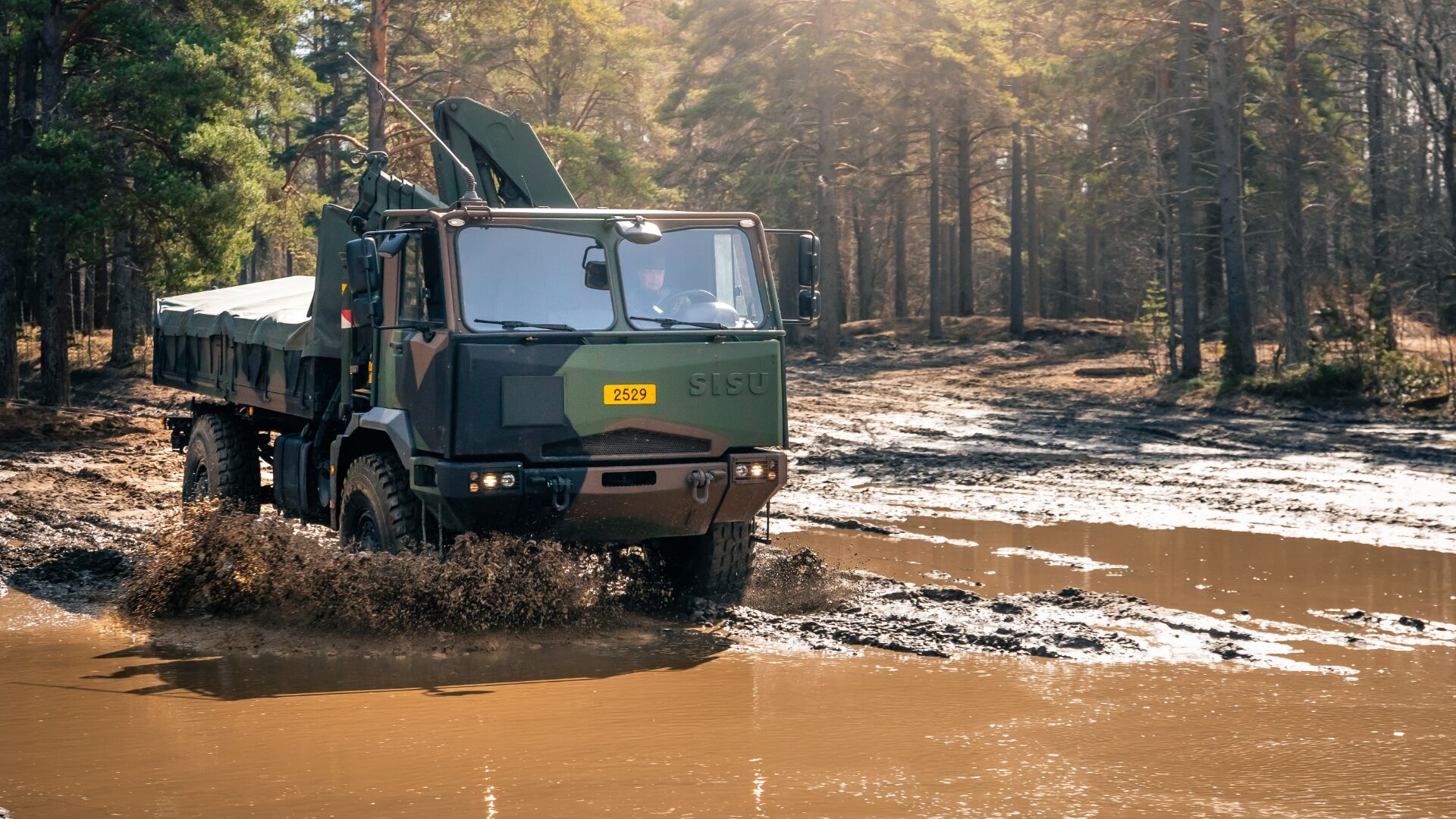 Un camión militar sobre una superficie mojada y embarrada
