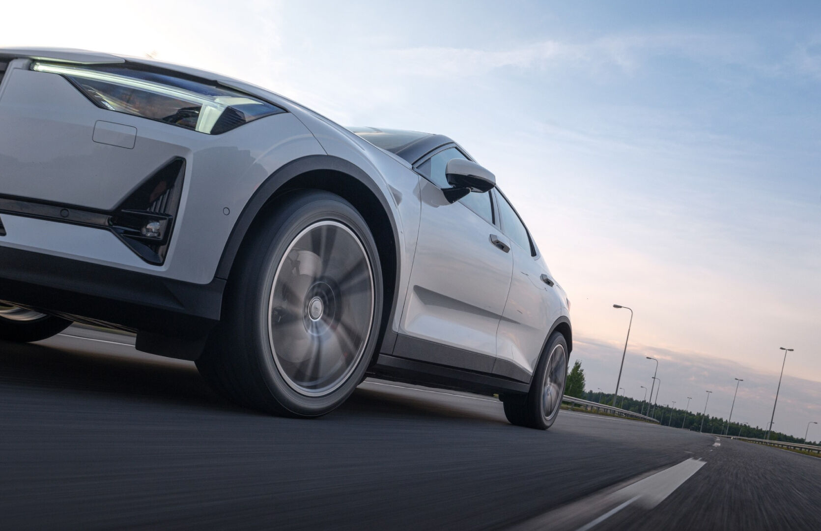 valkoinen auto läheltä kuvattuna ajamassa moottoritiellä